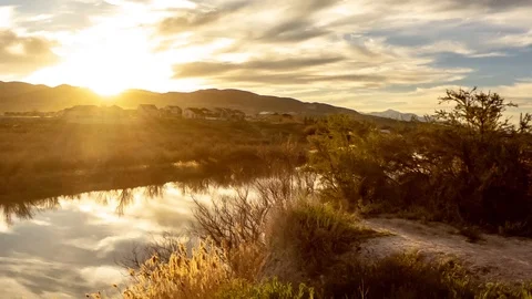 Sliding day-to-night time lapse of a sunset beyond a river Stock Footage 106736683