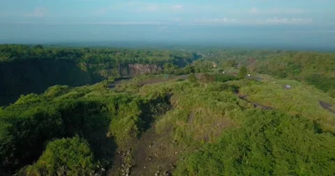 Sliding drone shot of slope of mountain with grass vegetation with valley Vidéo 210407294