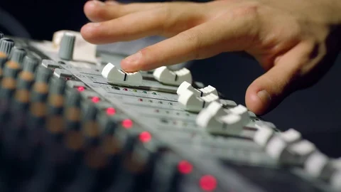 Sliding fader down on 16 track audio mixer board at voiceover session Stock Footage 86534442