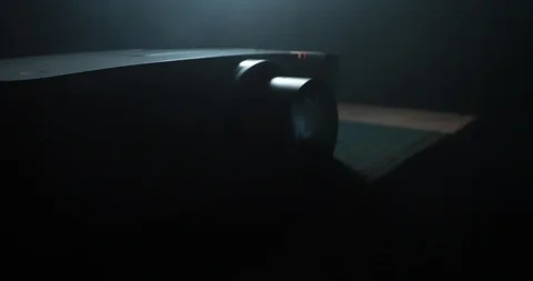 Sliding into the light beam of a projector as it turns on. Stock Footage 91241319