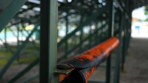 Sliding up over the underside of high school bleachers at a stadium Stock Footage 90400758