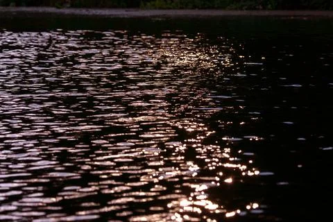 The sliding rays of the sun created contrasting reflections on the surface .. Stock Photos