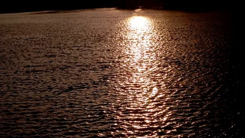 Sliding shot from boat of sunlight Reflection in waves in the sunset Video stock 87959748