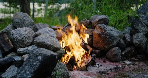 Sliding shot of a campfire burning in middle of rocks and stones. Stock Footage 112113673