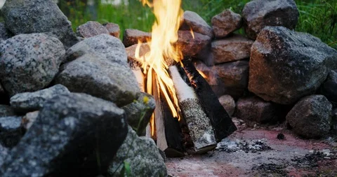Sliding shot of a campfire burning in middle of rocks and stones. Stock Footage 112113731