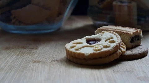 Sliding shot right of stack of three mixed biscuits on wooden surface. Stock Footage 98972149