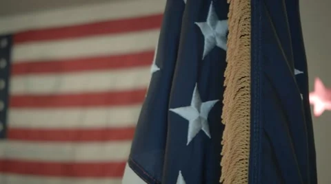 Sliding shot of US Flag in foreground with larger flag unfurled in background Stock Footage 57222099