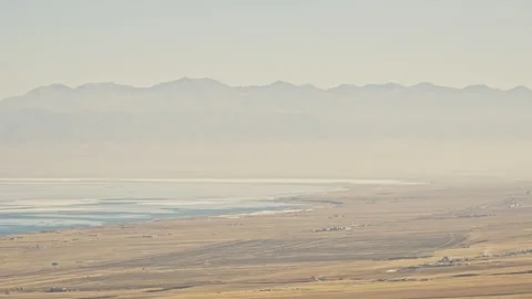 Slight Aerial View of Expansive Grassland with Mountains and Ocean Ice Floes Stock Footage 326423962