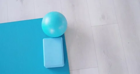 Slight camera nudge is making turquoise ball and foam-block roll and settle on 動画素材 339230022