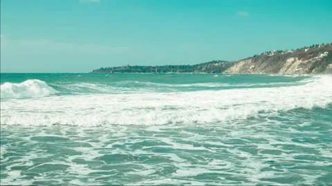 Slight swell in ocean during a storm with gusty winds waves splashing on a Beach Stock Footage 230486405