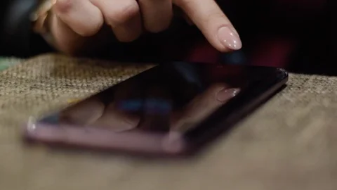 Slightly blurred mobile phone on table being unlocked and operated by Stock-Footage 104668784