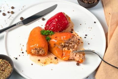 Slightly broken off with a fork stuffed pepper with herbs and spices on a white Foto stock
