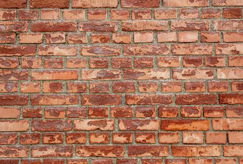 A slightly cracked red brick texture on the outside of a building Foto stock