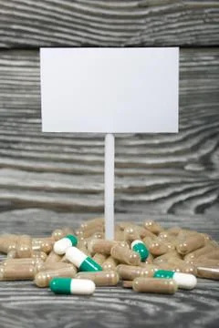 Slightly different pills on pine boards painted in black and white. Pointer w Stock Photos