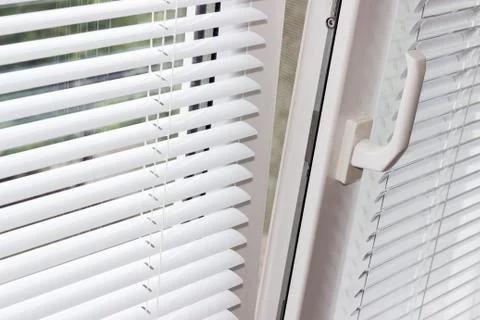 Slightly open modern plastic window with Venetian blinds Foto stock