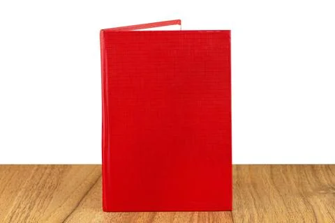 Slightly opened red lined notebook standing on a wooden table, isolated on a  Stock Photos