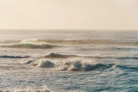 A slightly outoffocus image of waves breaking on a sandy shore Stock Photos