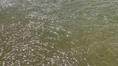 The slightly rippled water surface was streaked by the sun shining Stock Footage 234794581