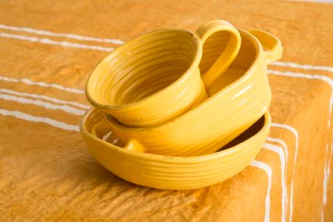 A Slightly Tilted Stack of Orange-Colored Earthenware on Orange-Colored Linen Stock Photos