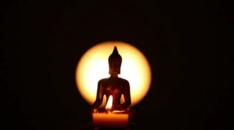 Slightly turning Buddha statue with candle Stock Footage 45955304