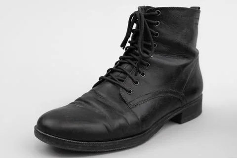 Slightly worn black shoe boot in leather with shoelaces Stock Photos