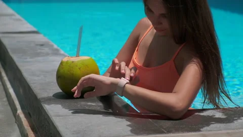 Slim active girl using smartwatch in open pool Stock Footage 135886020