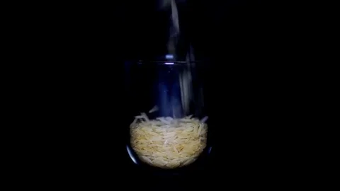 Slim and lengthy raw long grain rice in transparent glass on black background 스톡 동영상 75931938