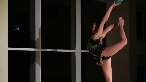 Slim girl athlete performs elements of rhythmic gymnastics with ball in gym Stock Footage 104126738