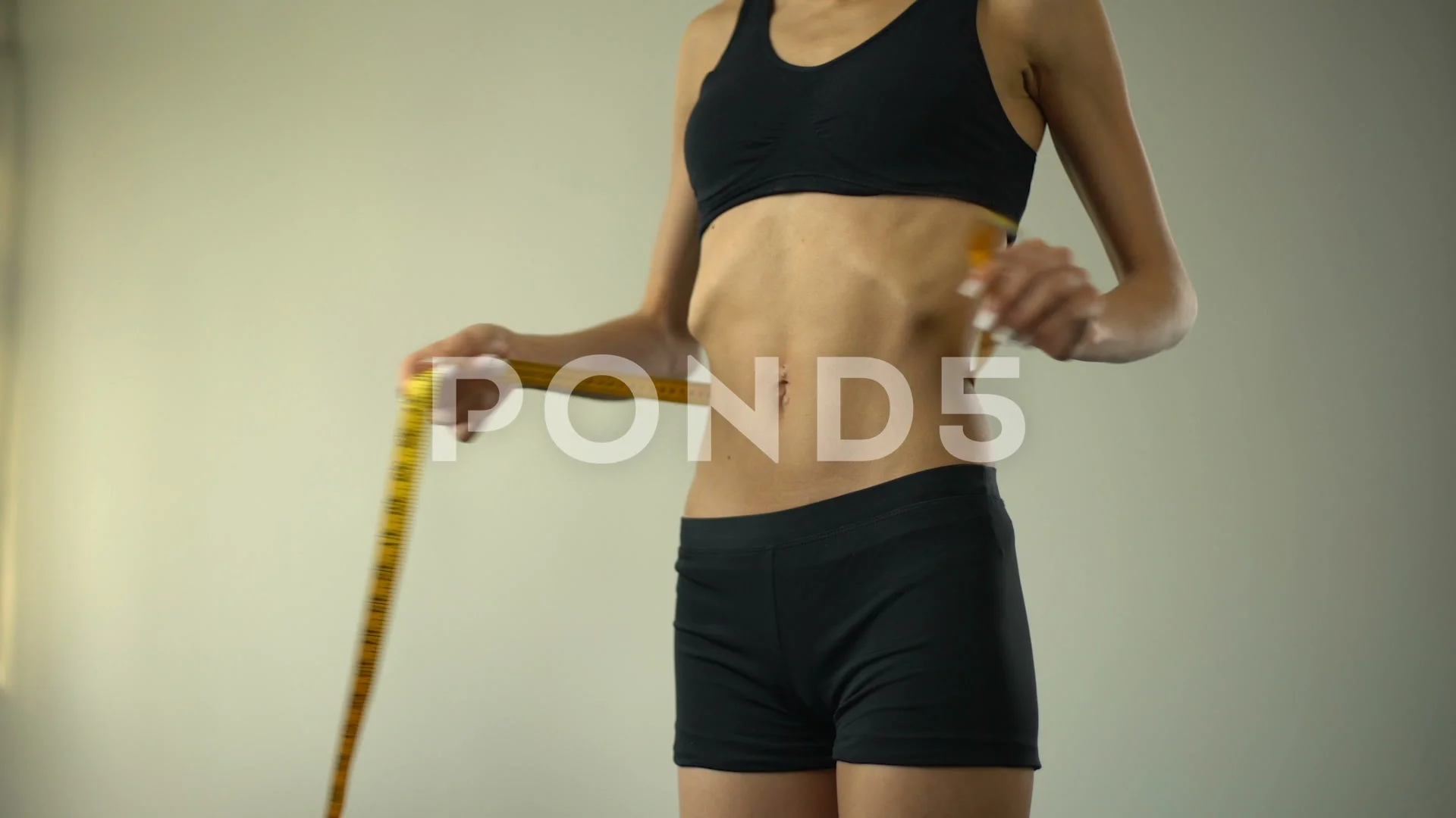 Slender woman measuring her waist with metric tape measure after a diet,  isolated 16406784 PNG