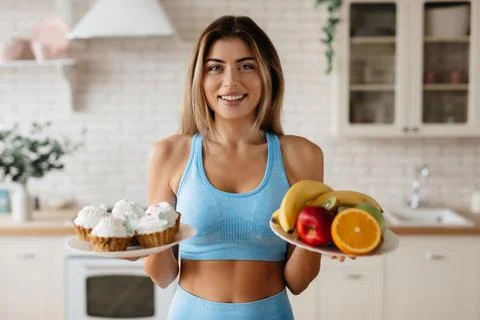 Slim lady choosing between options of nutrition Stock Photos
