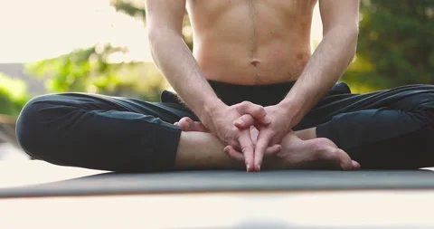 Slim man doing yoga exercises in city park outdoors.Guy wearing black pants Stock Footage 158331684