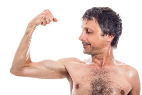 Slim man looking at biceps Stock Photos