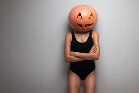 Slim model posing with pumpkin on head. studio Stock Photos