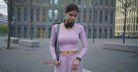 Slim woman checks time at smartwatch waits for athletic meeting to start going Stock Footage 159727983