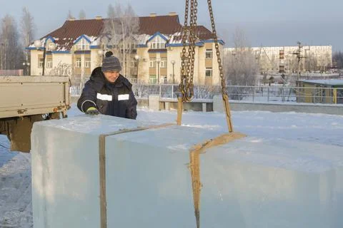 Slinger in a blue jacket unloading ice blocks 스톡 사진