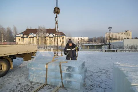 Slinger in a blue jacket unloading ice blocks 写真素材