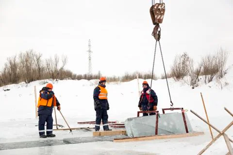 Slingers control the rise of ice blocks. 写真素材