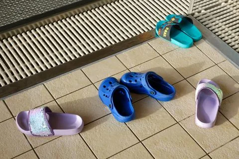 Slippers at the edge of the pool Stock Photos