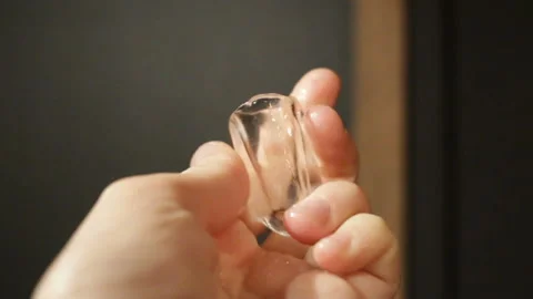 A slippery, transparent, cylindrical piece of ice in the hand. Real time, contai Stock Footage 129896522