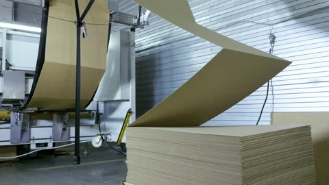 Slitting machine carves cardboard boxes from sheets of cardboard. 4K Stock Footage 168488681