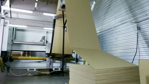 Slitting machine carves cardboard boxes from sheets of cardboard. 4K Stock Footage 205730610