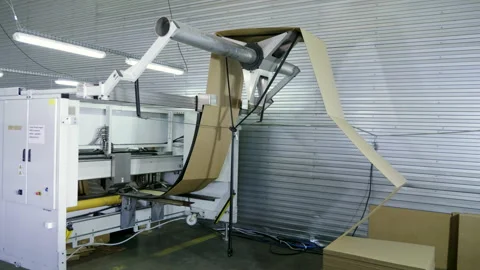 Slitting machine carves cardboard boxes from sheets of cardboard. 4K Stock Footage 205732147