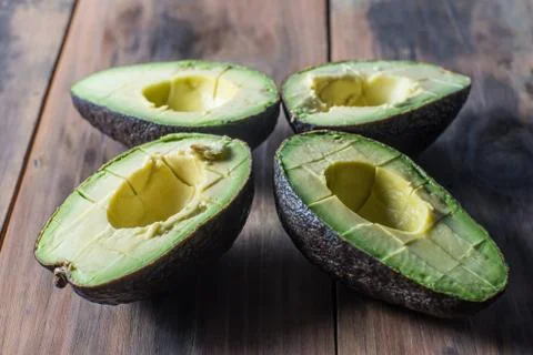 Slives of ripe avocado on rustic surface Stock Photos