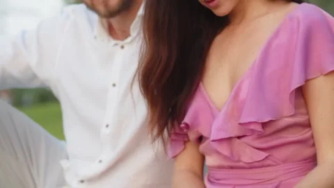 Slo mo boyfriend touching hair beautiful girlfriend during reading book and Stock Footage 256146053