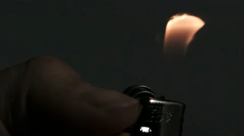 SLO MO CU Hand igniting cigarette lighter against black background Stock Footage 11292817