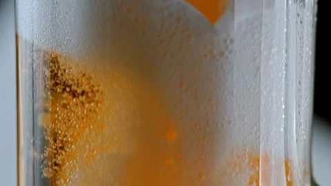 SLO MO DS Light beer being poured into a glass bubbles, foam and vibrant ambe Stock Footage 265766598