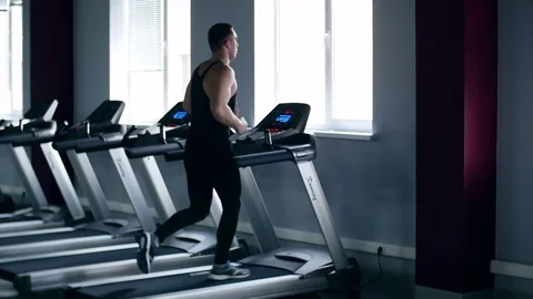 SLO MO LA Medium Shot Pan Man jogging on treadmill 動画素材 75356014