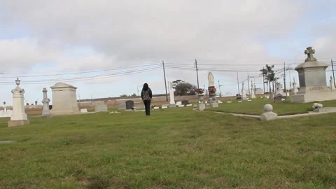Slo-mo of person walking past graves Stock Footage 155384700