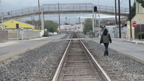 Slo-mo shot from afar, walking on railroad tracks Stock Footage 155489210