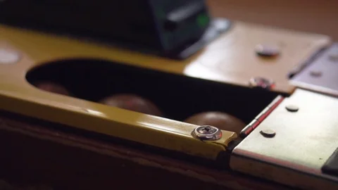 A Slo-mo shot of a hand grabbing a skee-ball from the machine. Stock Footage 93239447